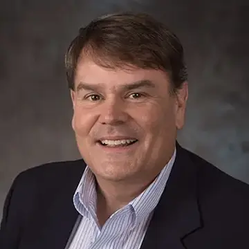 person smiling, wearing suit, gray background