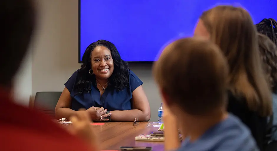 professor sitting around a table with students