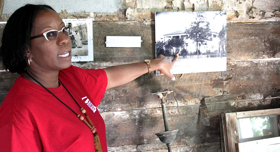 Faculty member pointing to a historic photo on a wall