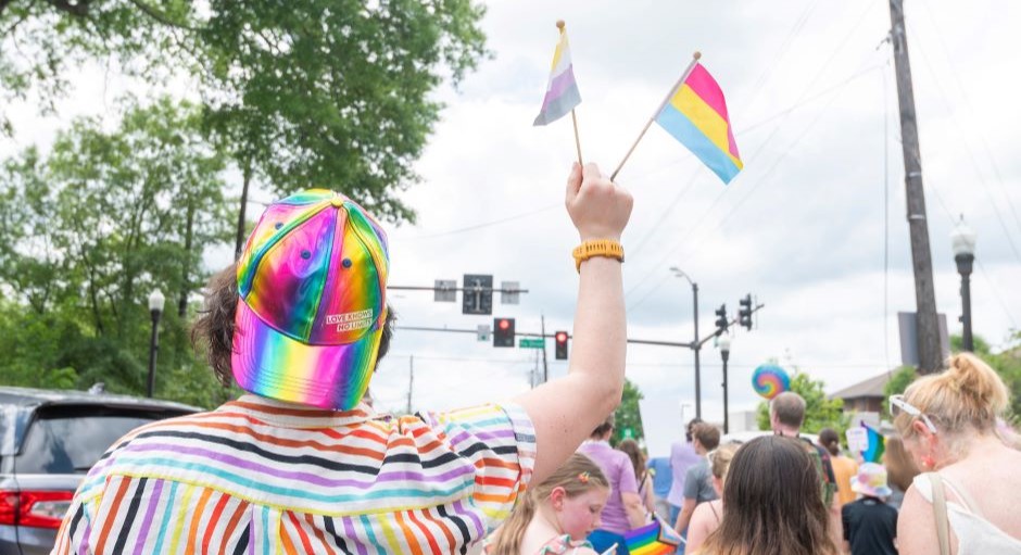 image from a pride parade with someone holding flags