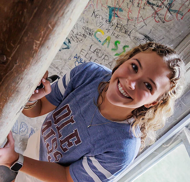 Alice Ann Hollingsworth, a senior English major from Jackson, signs her name in the turret of Ventress Hall. 