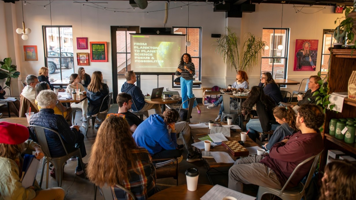 faculty member giving a presentation at a local coffee shop