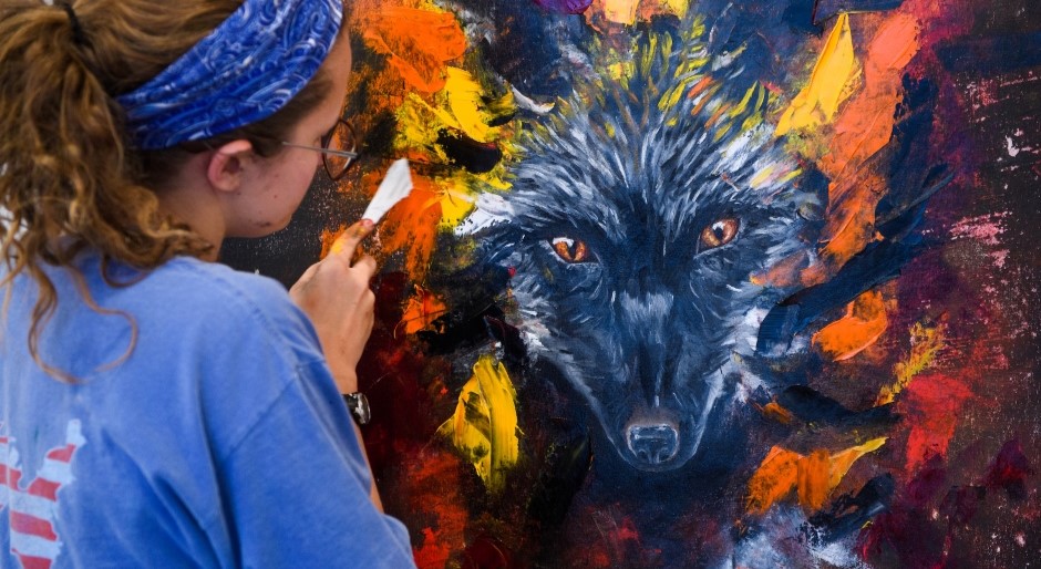 art student painting a colorful wolf