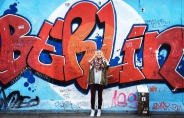 Image of student standing in front of Berlin wall