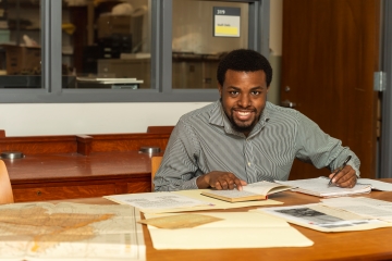 student working at a table in library 