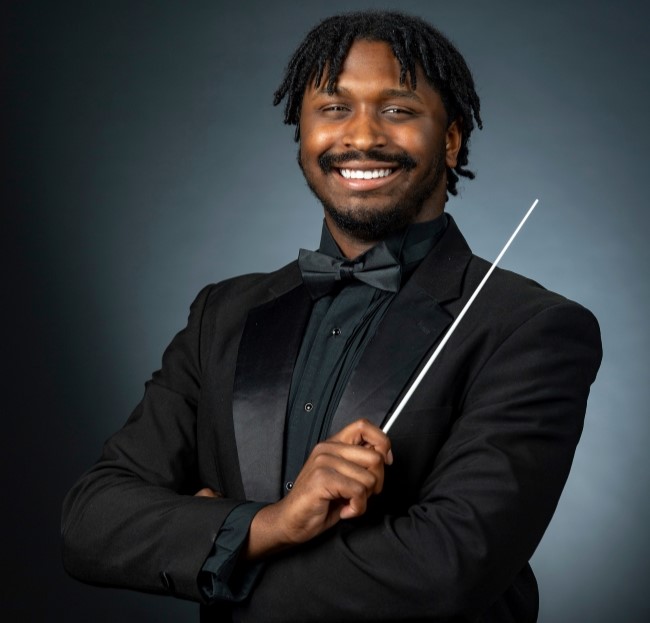 student holding a conductor wand