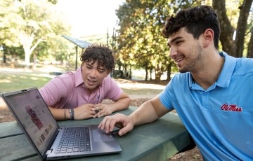 students studying in the Grove at a picnic table