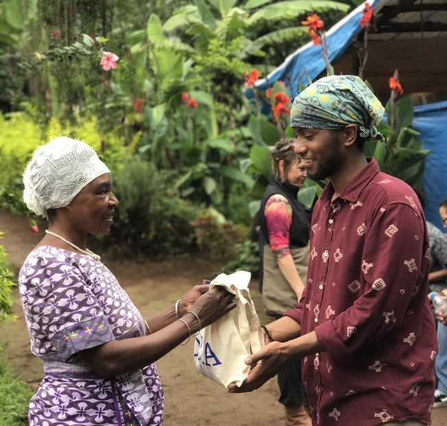 African woman handing a bag to a university student