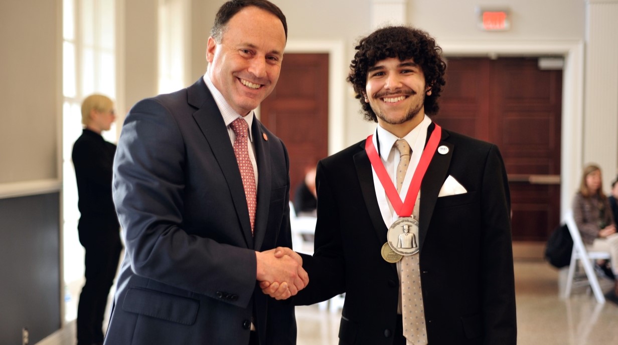 student shaking the hand of the dean while receiving an award