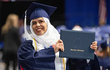 student holding her diploma cover at graduation