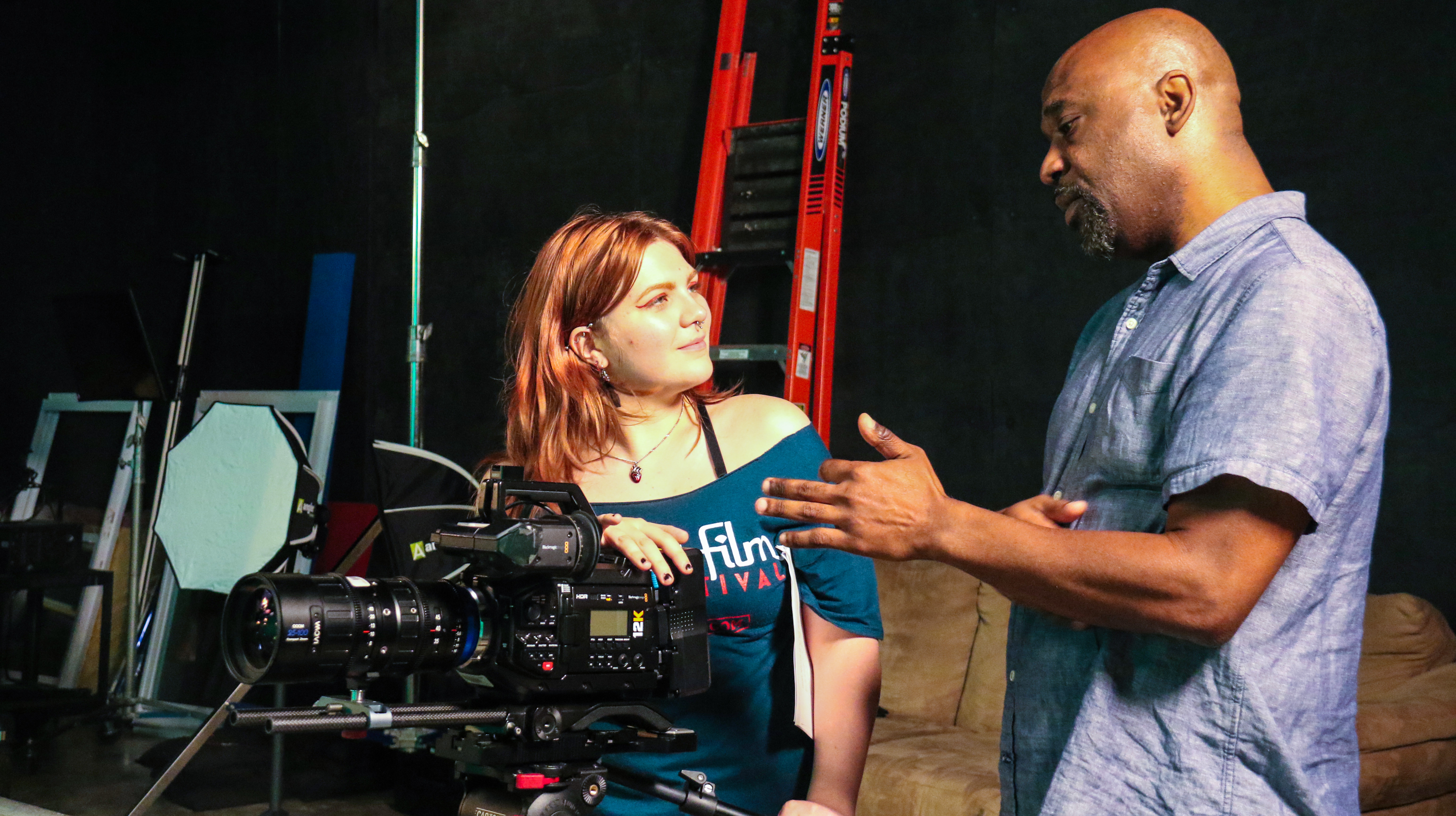 two people talking to each other around a camera