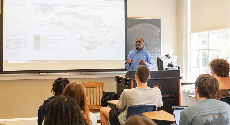 An African American Studies professor teaches in front of a class.