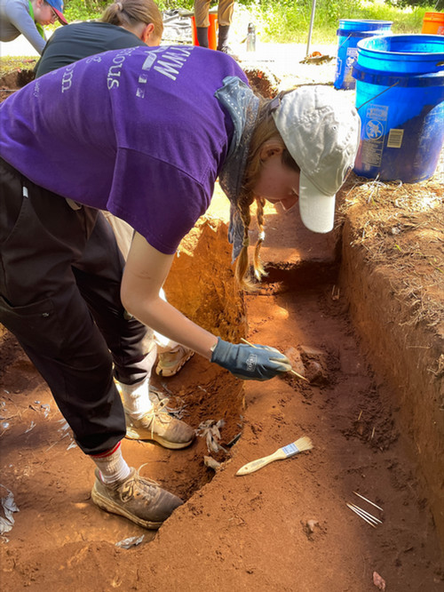 girl carefully digging in an archaeological site