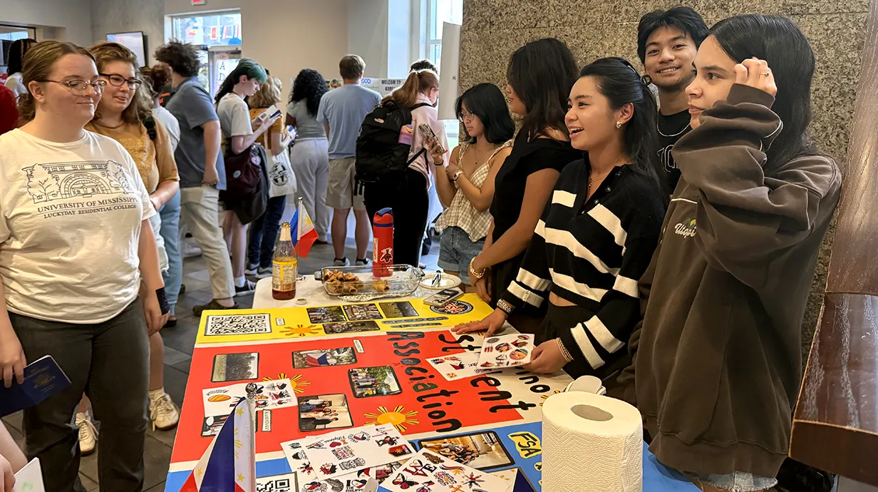students standing around table with colorful posters/
