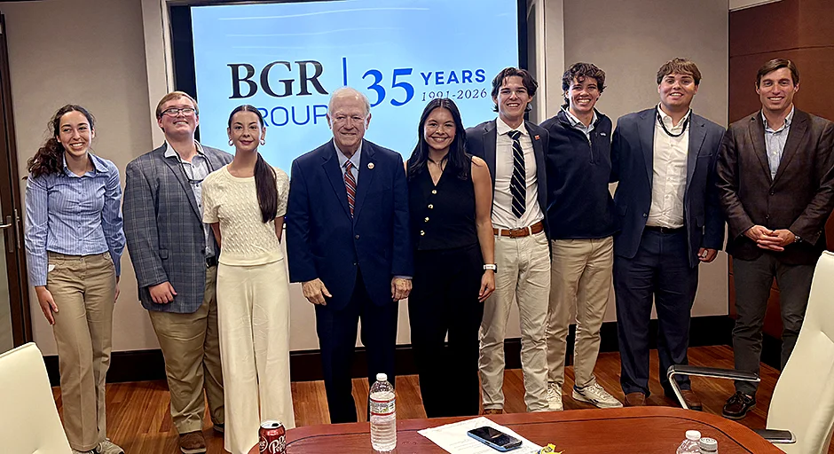 nine people standing in front of a sign that reads, "BGR Group | 35 years 1991-2026" in a stately office