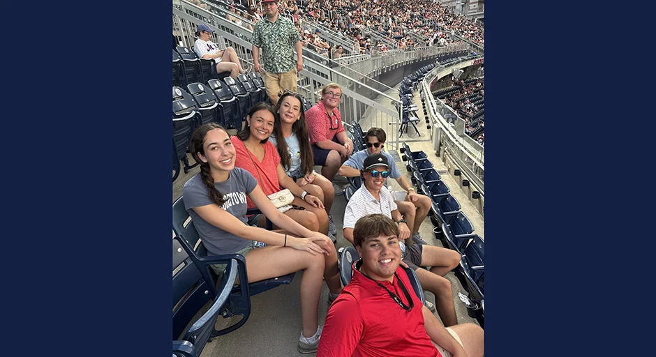 Group of seven people seated at a baseball game