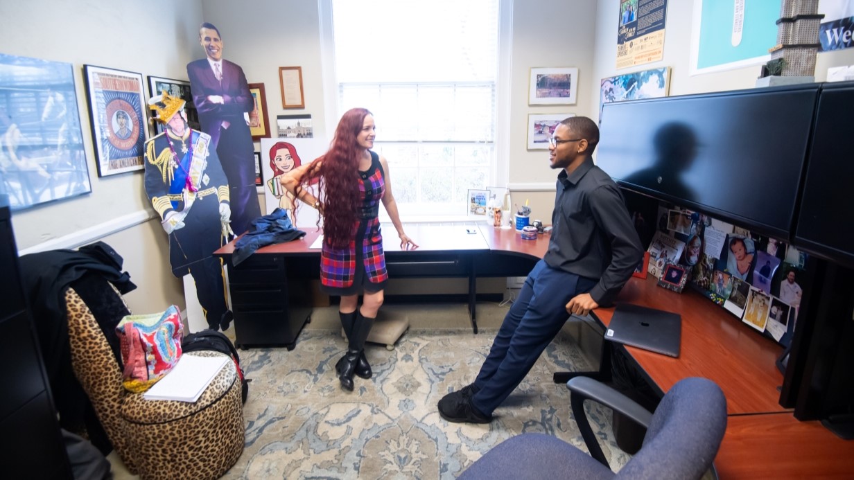 faculty member and graduate student standing and talking together in her office