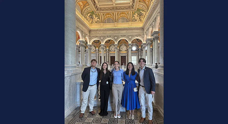 Group of five standing in front of an extremely ornate atrium.