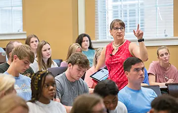 Faculty member standing in a classroom of students