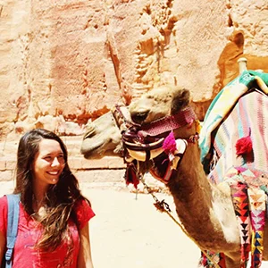 person looking at camel in desert setting