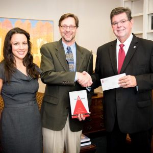 Ken Sufka (center), UM professor of psychology and pharmacology, and wife, Stevi, have established a scholarship from royalties received from the publication of Sufka's book. UM Provost Morris Stocks (right) was instrumental in making the book required reading for all entering students.