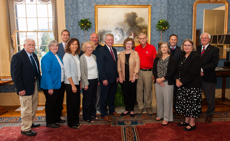 Dr. Rhett Atkinson (in red) and his wife Elaine (center) established the Doctors Andrew Stefani and Eldon Miller Memorial Chair for STEM Teaching and Research Endowment. Pictured with the Atkinsons are members of the Stefani and Miller families and UM administrators. They are (from left) Roger and Mary Jane Thornton (JoAnn Stefani’s sister and brother-in-law); Denson Hollis, executive director of development; Anne Stefani (Dr. Stefani’s daughter); JoAnn Stefani (Dr. Stefani’s wife); Patrick Booth (Anne Stefani’s husband); UM Chancellor Glenn Boyce; the Atkinsons; Tonya Dalton (Dr. Miller’s daughter); Lee Cohen, dean of the College of Liberal Arts; Christine Reiner (JoAnn Stefani’s sister); and Charles Hussey, associate dean for research and graduate education/professor of chemistry and biochemistry.