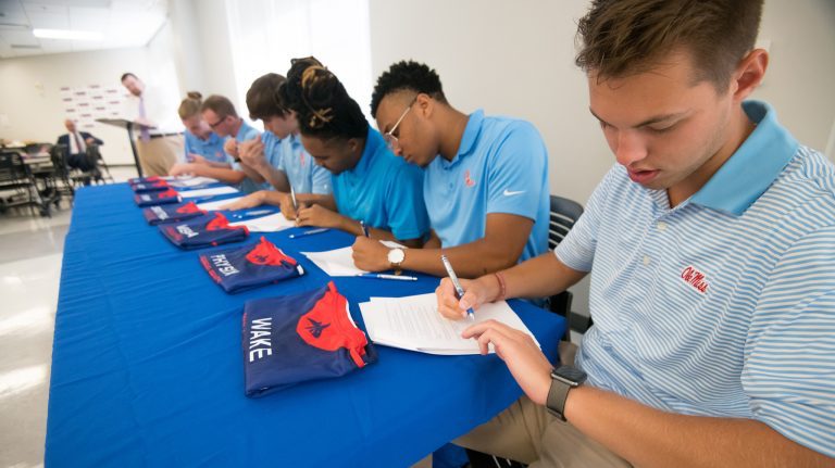 Will ‘Wake’ Primos (right) signs a contract with other members of the Ole Miss Rebels Esports Call of Duty team for the 2019-20 year. Photo by Kevin Bain/Ole Miss 