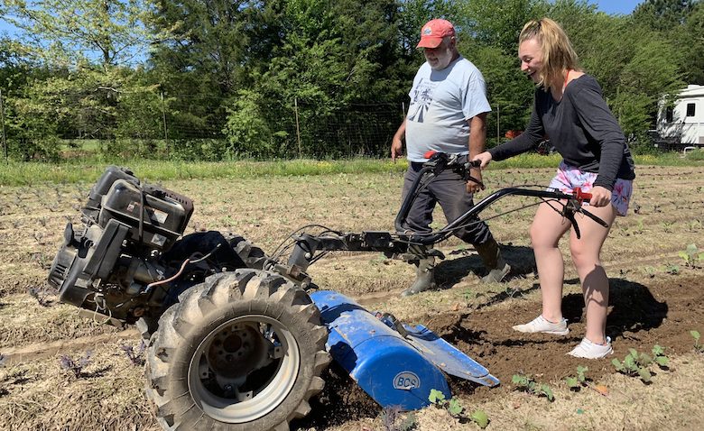 Ole Miss student Clementina Ferraro (right), a member of Emily Cooley’s ‘From Farm to Fork’ LIBA 102 class, tries her hand at farming alongside Doug Davis, owner of Yokna Bottoms Farm. Photo by Emily Cooley