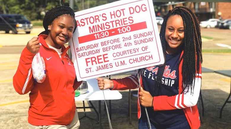 Jilkiah Bryant (right), a freshman CEED Innovation Scholar at the UM McLean Institute from Macon, and Tyra Lockett, a freshman biology major, pose for a photo between waves of people stopping by to get food at St. James Methodist Church in Columbus last fall. 