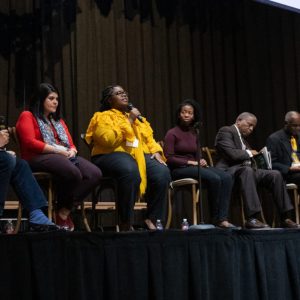 Panelists at the 2019 MUMI Conference are (from left) W. Ralph Eubanks, Katherine Aberle-Flores, Kiara Johnson, Jasmine Stansberry, Theophilus King, Donald Cole and Minahil Khan. Below: UM assistant professor of history Garrett Felber addresses attendees of the 2019 MUMI Conference.