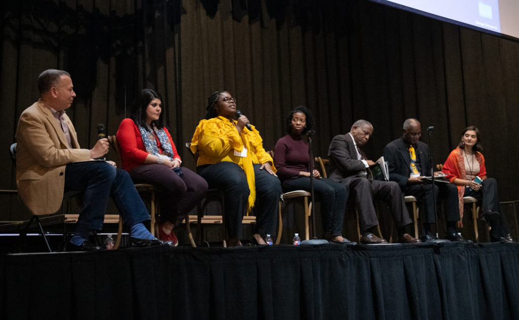 Panelists at the 2019 MUMI Conference are (from left) W. Ralph Eubanks, Katherine Aberle-Flores, Kiara Johnson, Jasmine Stansberry, Theophilus King, Donald Cole and Minahil Khan. Below: UM assistant professor of history Garrett Felber addresses attendees of the 2019 MUMI Conference.