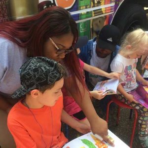 UM social work graduate Armonti Johnson (left) helps children pick out books and read at the LOU mobile library. The New Albany native is a member of the Americorps VISTA program and has served organizations throughout north Mississippi. Submitted photo