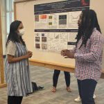 Jared Barnes (right), a senior biology major from Grenada, talks about his biodegradable drug delivery system research during a poster presentation for the UM Summer Undergraduate Research Group Grant program. Photo by Shea Stewart/UM Office of Research and Sponsored Programs