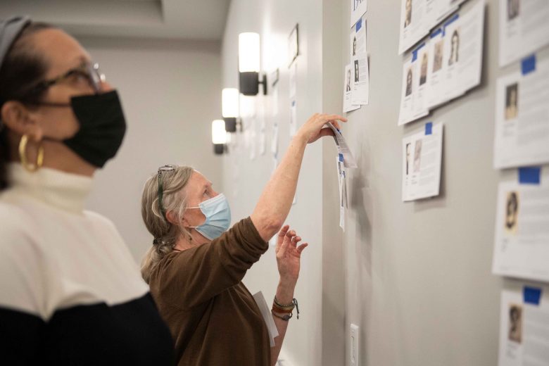 Laura Boughton, facilitator of the partnership between the University and the Holocaust Museum, tapes a piece of paper to the wall as a part of a participatory timeline activity. 