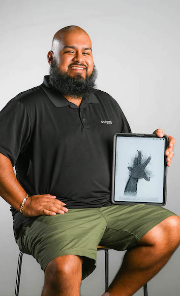 Frank Estrada, visual resources specialist and gallery curator in the Department of Art and Art History, shows a piece he developed during his staff creative residency, in which he worked on his augmented reality and animation skills. Photo by Bruce Newman Photography