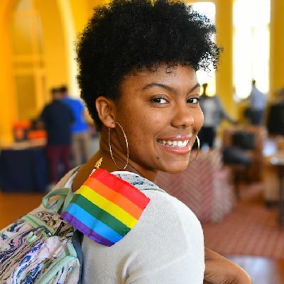 Student with rainbow flag sticking out of her backpack