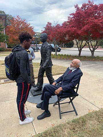 Cellas Hayes, standing, talking to a sitting James Meredith.