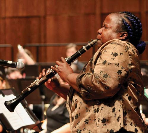 Profile view of Doreen Ketchens as she plays the clarinet. Her eyes are closed.